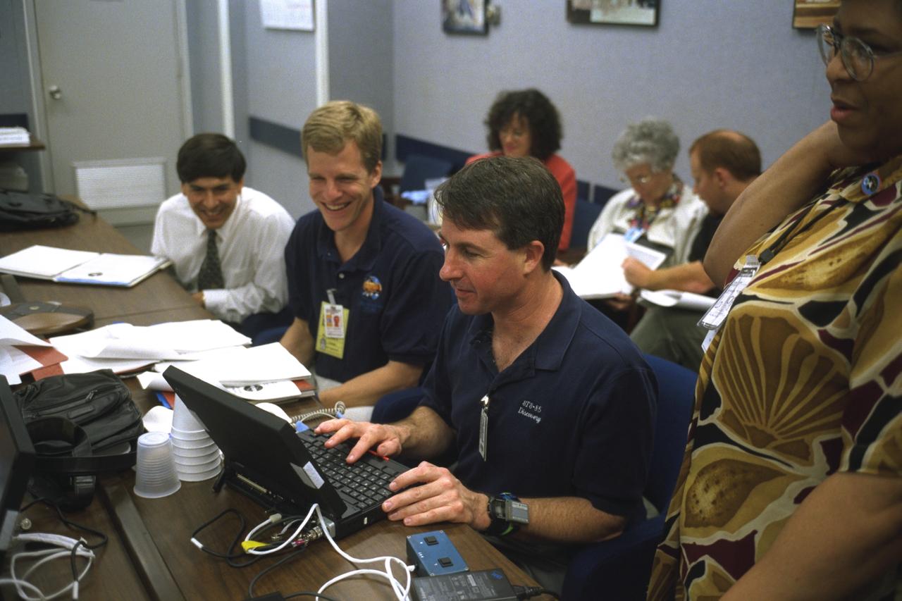 S98-08742 (May 1998) --- Two mission specialists assigned to the STS-95 flight rehearse some of their duties for the scheduled late October launch of the Space Shuttle Discovery. Stephen K. Robinson inputs data on the laptop computer while Scott E. Parazynski looks on. The photo was taken by Joe McNally, National Geographic, for NASA.