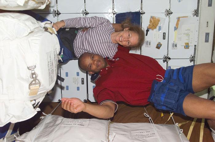 STS98-E-5005 (8 February 2001) -- Astronauts Marsha S. Ivins and Robert L. Curbeam,  mission specialists, are seen on the mid deck of the Earth-orbiting Space Shuttle Atlantis in one of the first STS-98 digital still camera scenes to be down linked from the shuttle.