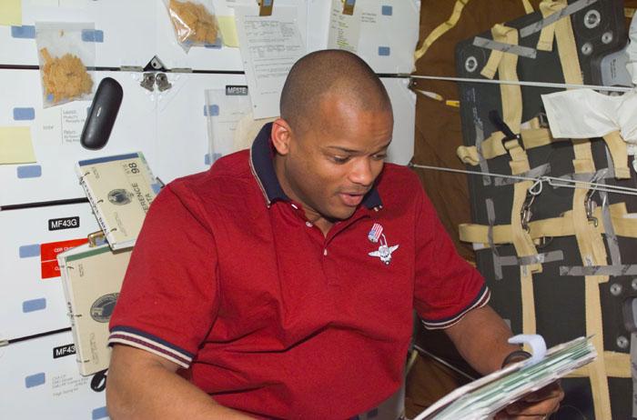 STS98-E-5009 (8 February 2001) --- Astronaut Robert L. Curbeam, mission specialist, reads over a duty schedule on the mid deck of the Space Shuttle Atlantis during early stages of the STS-98 mission. The scene was recorded with a digital still camera.