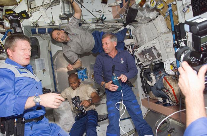 S98-E-5051 (9 February 2001) --- Astronaut William M. (Bill) Shepherd (left foreground), Expedition One commander, looks into the camera lens of a fellow crew member while three STS-98 visitors check out the International Space Station (ISS).  Astronaut Kenneth D. Cockrell, STS-98 mission commander, is at right; astronaut Mark L. Polansky, pilot, floats above and behind the shuttle commander; and astronaut Robert L. Curbeam, mission specialist, inspects a camera at bottom center. This scene was recorded with a digital still camera.