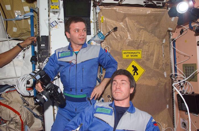 S98-E-5052 (9 February 2001) --- Cosmonauts Yuri P. Gidzenko, Expedition One's Soyuz commander; and Sergei K. Krikalev, flight engineer, look on as five visitors (out of frame) ingress the International Space Station (ISS) from the recently-docked Space Shuttle Atlantis. This scene was recorded with a digital still camera.