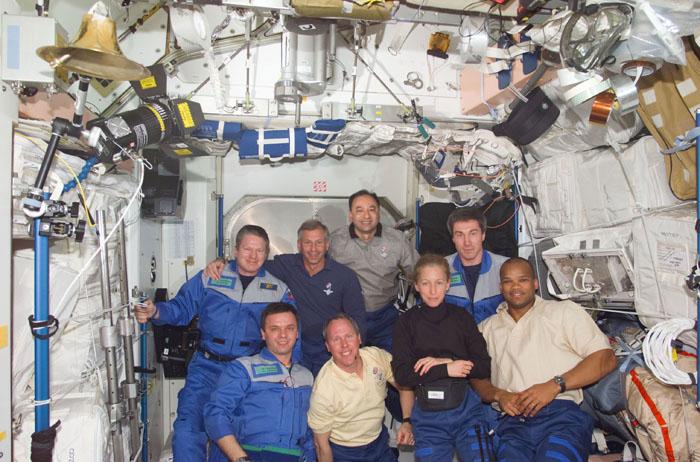 STS98-E-5053 (9 February 2001) --- The three-man Expedition One crew hosts its second group of visitors since beginning occupancy of the International Space Station in November of last year. A pre-set digital still camera was used to record the gathering. Wearing blue flight suits for the  reunion are the station's first fulltime occupants--astronaut William M. (Bill) Shepherd (rear left), Expedition One commander;cosmonaut Yuri P. Gidzenko (front left), Soyuz commander; and cosmonaut Sergei K. Krikalev (rear right), flight engineer. Astronauts Kenneth D. Cockrell (second left, rear) and Mark L. Polansky (second right, rear) are STS-98 mission commander and pilot, respectively. Astronauts Thomas D. Jones, Marsha S. Ivins and Robert L. Curbeam--all mission specialists--are in front.  Atlantis docked to the station on schedule at 10:51 a.m. (CST), Feb. 9 and the station and shuttle crews opened hatches between the spacecraft at 1:03 p.m., promptly  beginning to unload supplies. The three-member station crew, on the eve of their 100th day aboard the outpost, greeted their first visitors in almost two months. The hatches were open for about four hours before they were closed in preparation for the first of three upcoming space walks, a six-hour sojourn scheduled for the following day from Atlantis by Jones and Curbeam.