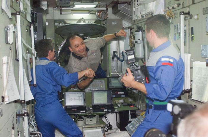 STS98-E-5056 (9 February 2001) --- Cosmonauts Sergei K. Krikalev (left), Expedition One flight engineer, and Yuri P. Gidzenko (left), Soyuz commander for the first station expedition crew, welcome astronaut Mark L. Polansky, STS-98 pilot, aboard the International Space Station.  The scene was recorded with a digital still camera shortly after the hatches were opened on STS-98 Flight Day 3.