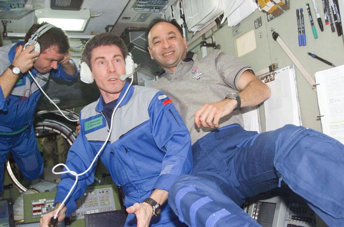 STS98-E-5061 (9 February 2001) --- Cosmonauts Sergei K. Krikalev (center), Expedition One flight engineer, and Yuri P. Gidzenko (left), Soyuz commander for the first station expedition crew, are pictured with astronaut Mark L. Polansky, STS-98 pilot, in the Zvezda Service Module of the International Space Station. The cosmonauts, who represent the Russian Aviation and Space Agency, are communicating with ground controllers in Russia. The scene was recorded with a digital still camera shortly after the outpost's hatches were opened on STS-98 Flight Day 3.