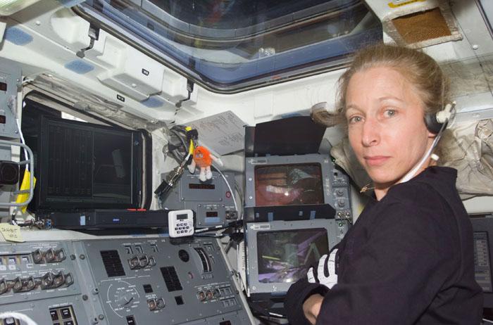 STS98-E-5078 (10 February 2001) --- Astronaut Marsha S. Ivins, STS-98 mission specialist, monitors communications from ground controllers from her post at the aft flight deck controls on the Space Shuttle Atlantis. The scene was recorded with a digital still camera.