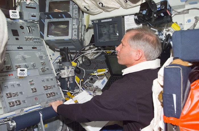 STS98-E-5083 (10 February 2001) --- Astronaut Kenneth D. Cockrell, STS-98 mission commander, is pictured on the  flight deck of the Space Shuttle Atlantis. Cockrell is reading a document dealing with the Unity node on the International Space Station.  The scene was recorded with a digital still camera.