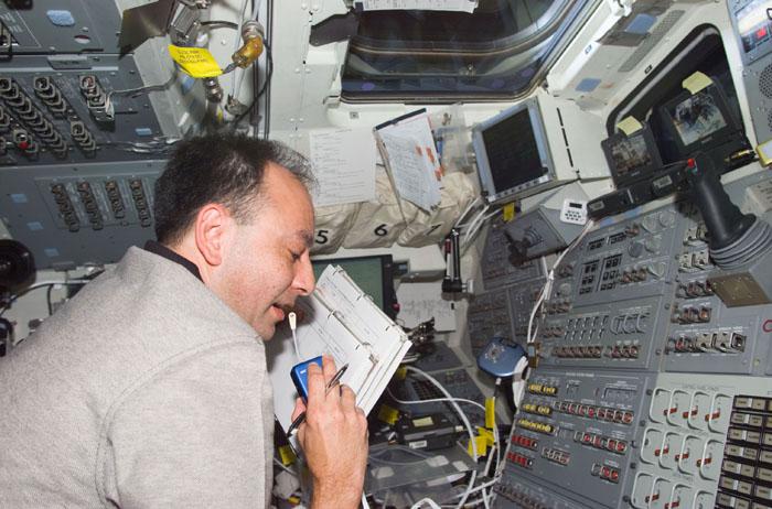 STS98-E-5086 (10 February 2001) --- Astronaut Mark L. Polansky, STS-98 pilot, communicates with ground controllers from his post at the aft flight deck controls on the Space Shuttle Atlantis. The scene was recorded with a digital still camera.