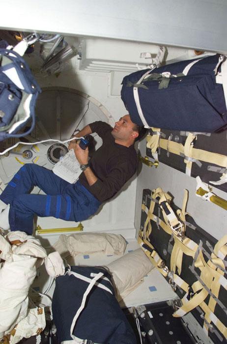 STS98-E-5088 (10 February 2001) --- Astronaut Mark L. Polansky, SS-98 pilot, communicates with ground controllers from the mid deck of the Space Shuttle Atlantis.  Parts of at least two sleep stations are visible in the digital still camera's scene.