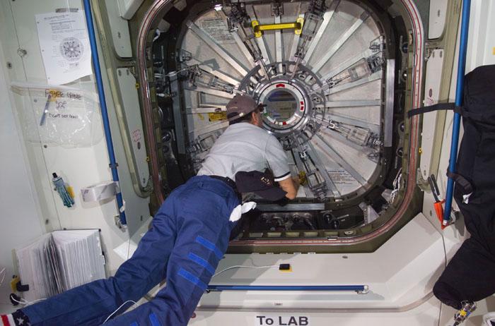 STS98-E-5115 (11 February 2001) --- This medium  shot, photographed with a digital still camera, shows STS-98 pilot  Mark L. Polansky looking through the observation port on Unity's closed hatch to the newly attached Destiny laboratory.  The crews of Atlantis and the International Space Station opened the laboratory shortly after this photo was made on Feb. 11; and the astronauts and cosmonauts spent the first full day of what are planned to be years of work ahead inside the orbiting science and command center. Station commander William M. (Bill) Shepherd opened the Destiny hatch, and he and shuttle commander Kenneth D. Cockrell ventured inside at 8:38 a.m. (CST), Feb. 11.  As depicted in subsequent digital images in this series, members of both crews went to work quickly inside the new module, activating air systems, fire extinguishers, alarm systems, computers and internal communications. The crew also continued equipment transfers from the shuttle to the station.