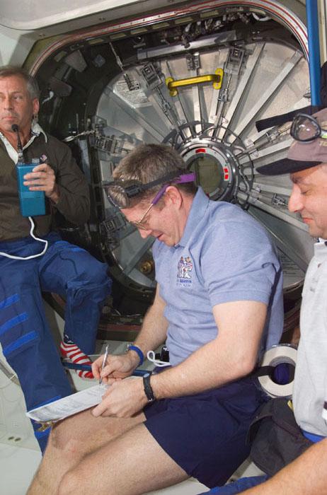 STS98-E-5125 (11 February 2001) --- Inside the Unity node, astronaut William M. (Bill) Shepherd (center), Expedition One commander, signs a document of receipt of the U.S. laboratory, called Destiny, as part of the International Space Station (ISS).  Looking on are astronauts Kenneth D. Cockrell (left) and Mark L. Polansky, commander and pilot, respectively, for STS-98. The hatch to Destiny, not yet opened, is in the background. This scene was recorded with a digital still camera.