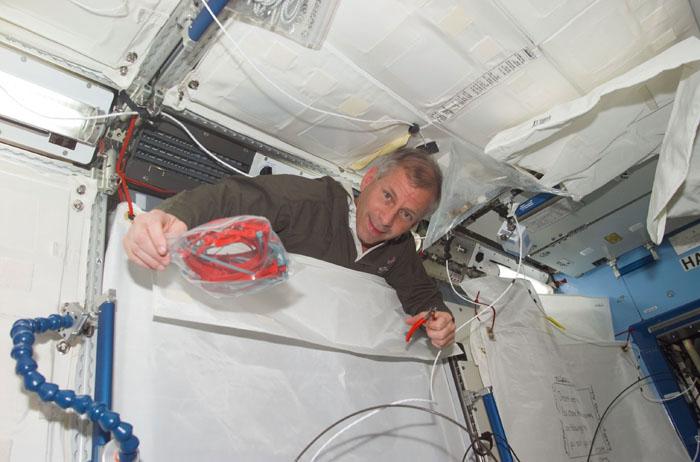 STS98-E-5150 (11 February 2001) ---  Astronaut Kenneth D. Cockrell, STS-98 commander, emerges from behind wall  covering in the newly attached Destiny  laboratory onboard the International Space Station (ISS).  After the Destiny hatch was opened early in the day, members of both crews went to work quickly inside the new module, activating air systems, fire extinguishers, alarm systems, computers and internal communications. The crews also took some photos and continued equipment transfers from the shuttle to the station. The scene was taken with a digital still camera.