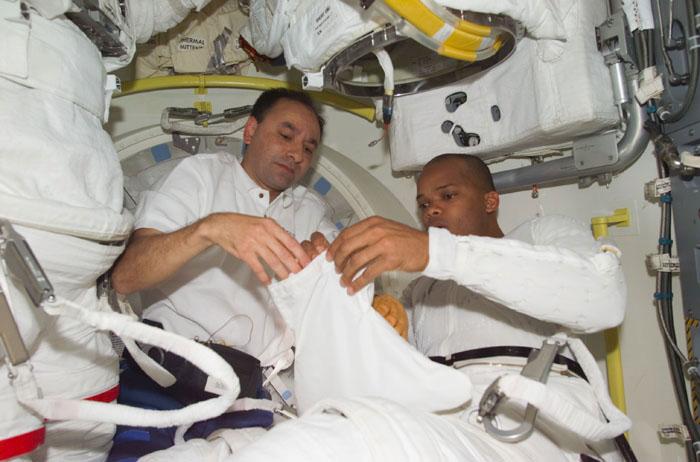 STS98-E-5179 (12 February 2001) --- Astronaut Robert L. Curbeam (right), STS-98 mission specialist, with the aid of astronaut Mark L. Polansky, pilot, dons his extravehicular mobility unit for the upcoming space walk on the International Space Station on February 12.  This scene was recorded with a digital still camera.