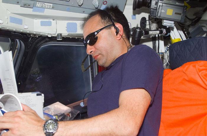 STS98-E-5203 (13 February 2001) --- Astronaut Mark L. Polansky, STS-98 pilot, checks out a detail in a flight plan at the pilot's station on the Space Shuttle Atlantis on February 13.  This scene was recorded with a digital still camera.
