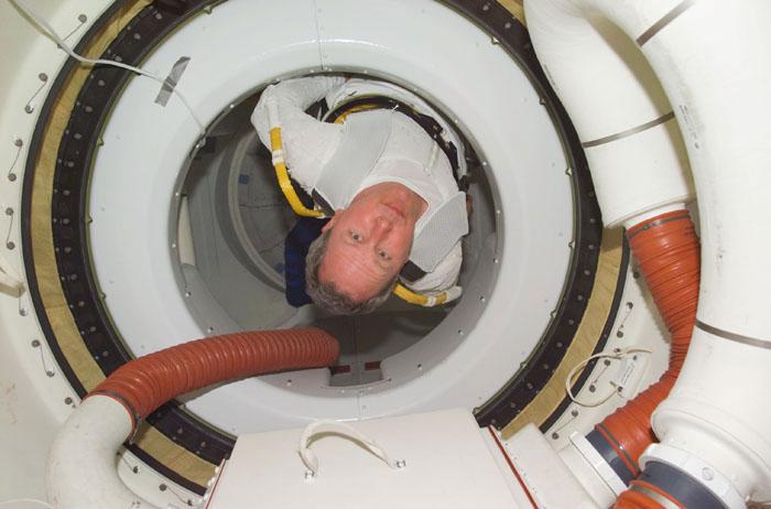 STS98-E-5223 (14 February 2001) ---  Astronaut Thomas D. Jones, mission specialist, dons his extravehicular mobility unit (EMU) space garment in the airlock of the Space Shuttle Atlantis in this high-angle view photographed with a digital still camera.  Jones was about to participate in the final of three space walks scheduled for the STS-98/5a mission.