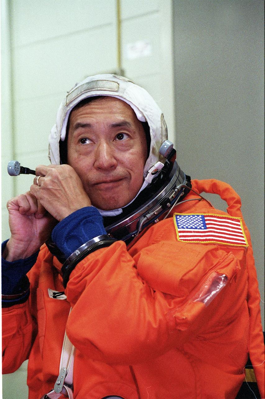 S99-05622 (19 May 1999) --- Astronaut Mamoru Mohri, mission specialist representing Japan's National Space Development Agency,  works with his communications gear prior to participating in emergency bailout training at the Johnson Space Center's  Systems Integration Facility.  Mohri  wears a training version of the partial pressure launch and entry garment.