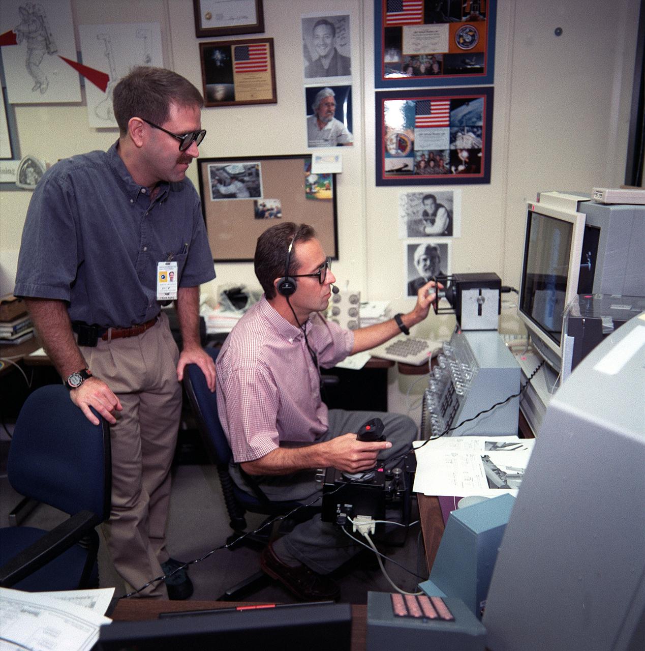 S99-05678 (24 May 1999)--- Astronaut Jean-Francois Clervoy (right), STS-103 mission specialist representing the European Space Agency (ESA), &quot;controls&quot; the shuttle's remote manipulator system (RMS) during a simulation using virtual reality type hardware at the Johnson Space Center (JSC).  Looking on is astronaut John M. Grunsfeld, mission specialist.  Both astronauts are assigned to separate duties supporting NASA's third Hubble Space Telescope (HST) servicing mission.  Clervoy will be controlling Discovery's RMS and Grunsfeld is one of four astronauts that will be paired off for a total of three spacewalks on the mission.