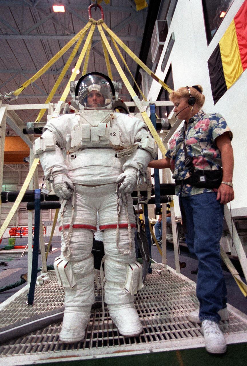 S99-05726 (26 May 1999) --- Astronaut Janet L. Kavandi, mission specialist,  is about to be lowered into a deep pool for an underwater training session. The training took place at the Johnson Space Center's Neutral Buoyancy Laboratory (NBL), part of the Sonny Carter Training Center.  Kavandi has weights on the training version of her extravehicular mobility unit (EMU) which help to provide neutral buoyancy in the pool.  Astronauts Kavandi and Gerhard P.J. Thiele were participating in a rehearsal of a contingency space walk for the STS-99 mission.