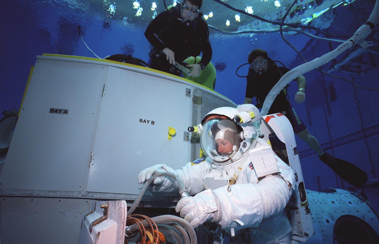 S99-06194 (21 June 1999) --- Astronaut C. Michael Foale, mission specialist, rehearses Extravehicular Activity (EVA) with the Hubble Space Telescope (HST) mockup in the Neutral Buoyancy Laboratory (NBL).