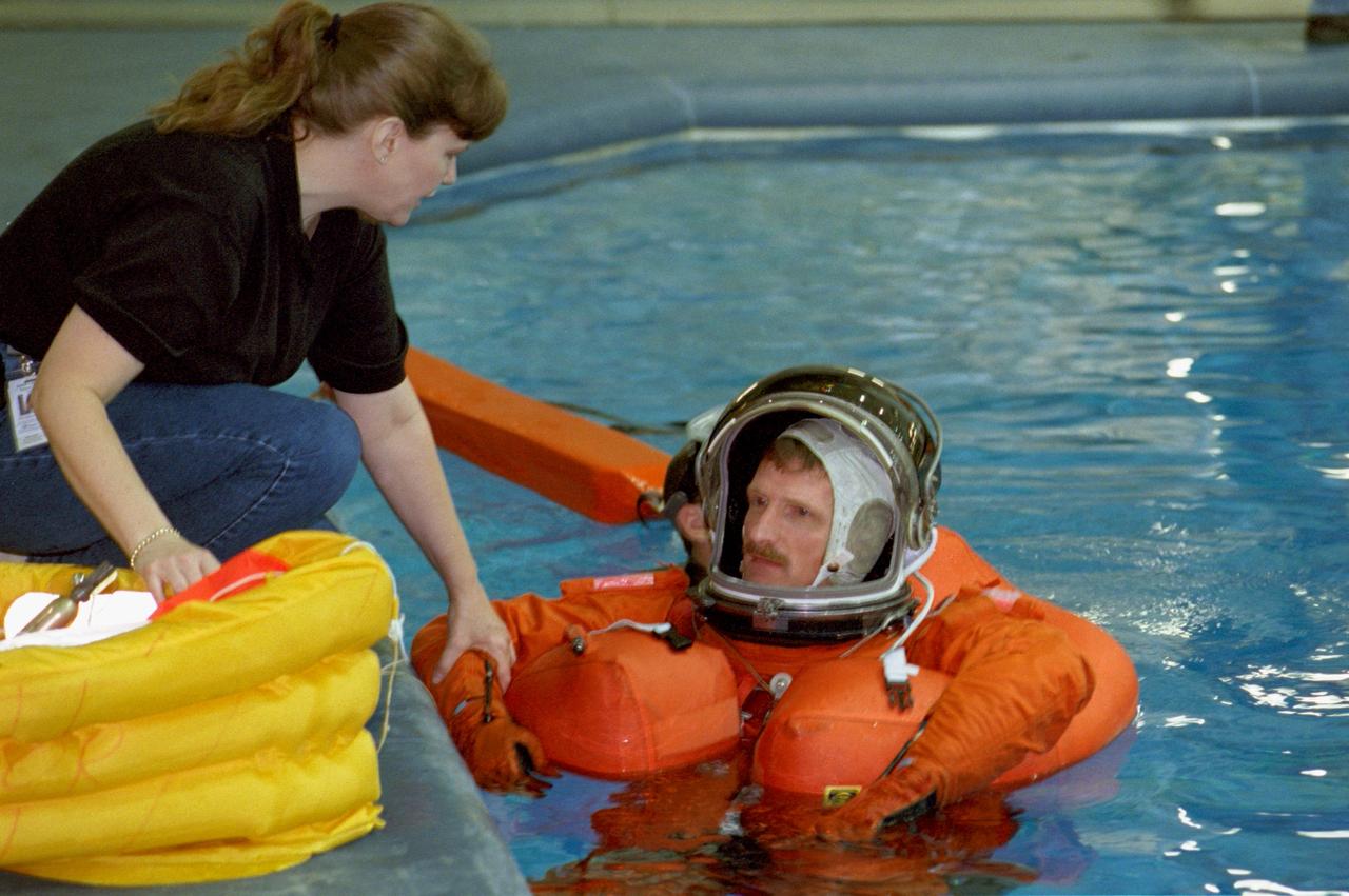 S99-07006 (9 July 1999) --- Sharon Jones, a member of the crew training staff, briefs astronaut Joseph R. Tanner during a bailout training exercise for the STS-97 crew in the Neutral Buoyancy Laboratory (NBL) at the Sonny Carter Training Center. Tanner is a mission specialist on the five-man STS-97 crew, scheduled for a visit to the International Space Station (ISS) next autumn.