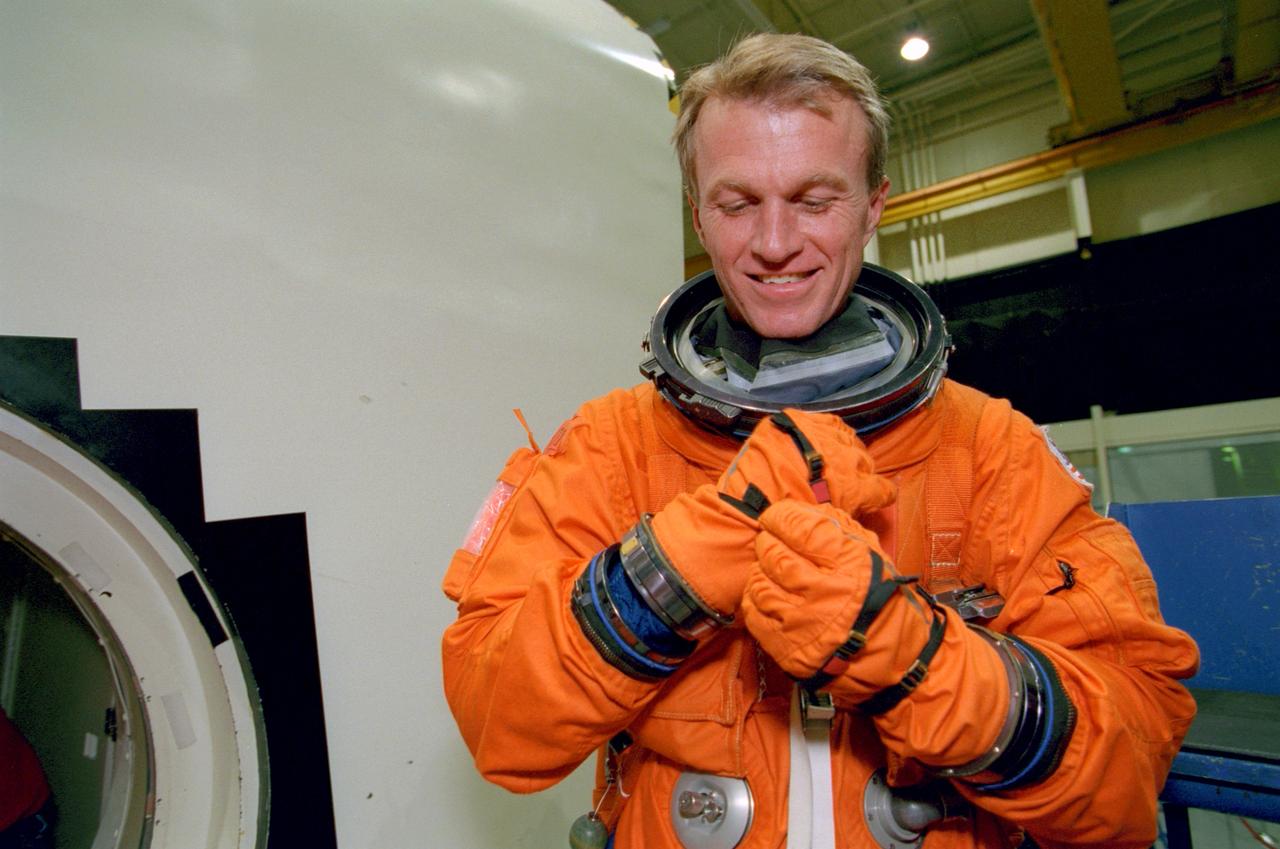 S99-07627 (15 July 1999) --- Astronant Brent W. Jett, STS-97 mission commander, adjusts a glove on his pressure suit during an emergency egress training excercise with the crew compartment trainer (CCT) in the Johnson Space Center's Systems Integration Facility.