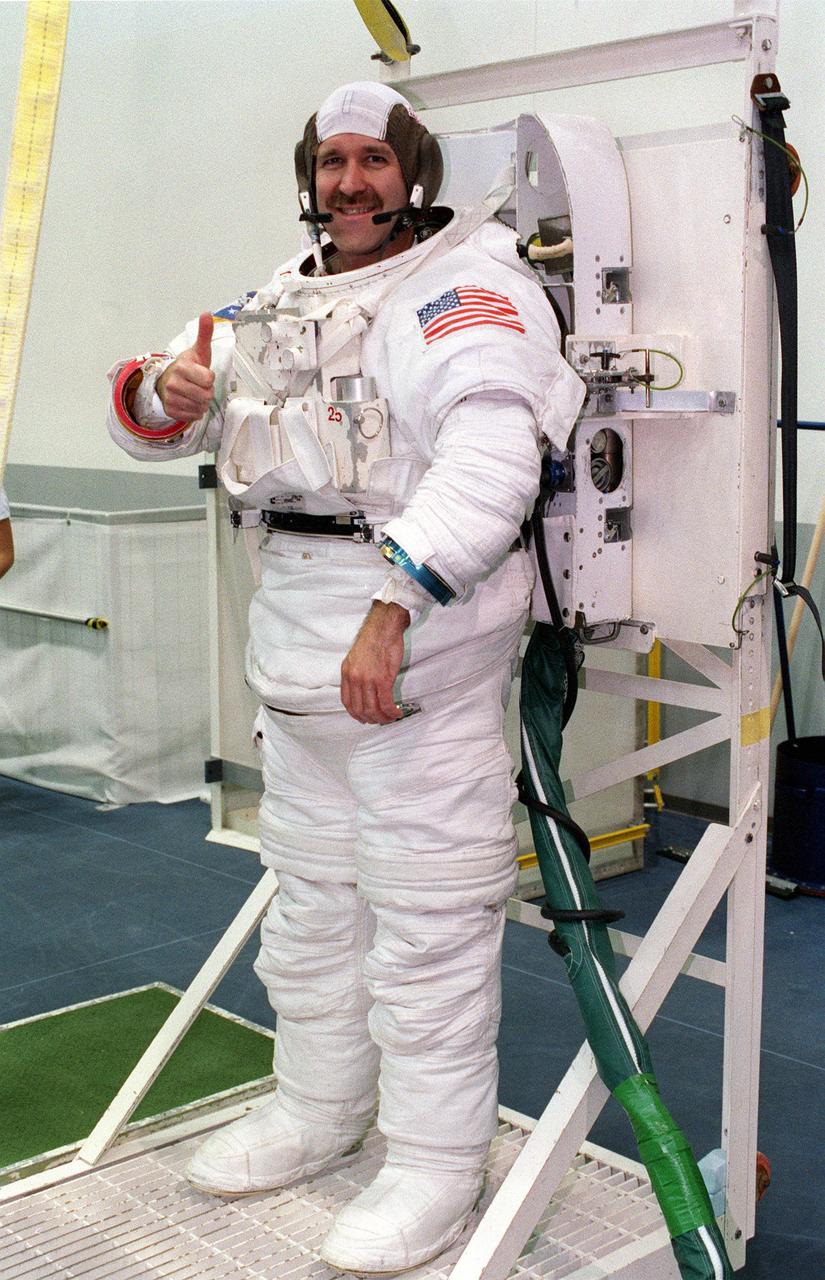 S99-08359 (26 July 1999) --- Astronaut John M. Grunsfeld, mission specialist, wearing an underwater-adapted training version of the Shuttle extravehicular mobility unit (EMU), signals "all's well" prior to going into the water in the Neutral Buoyancy Laboratory (NBL). Grunsfeld and other astronauts assigned to STS-103 space walk duty are in training for EVA chores they will handle when they make the third servicing visit to the Earth-orbiting Hubble Space Telescope (HST) since its deployment in April 1990.