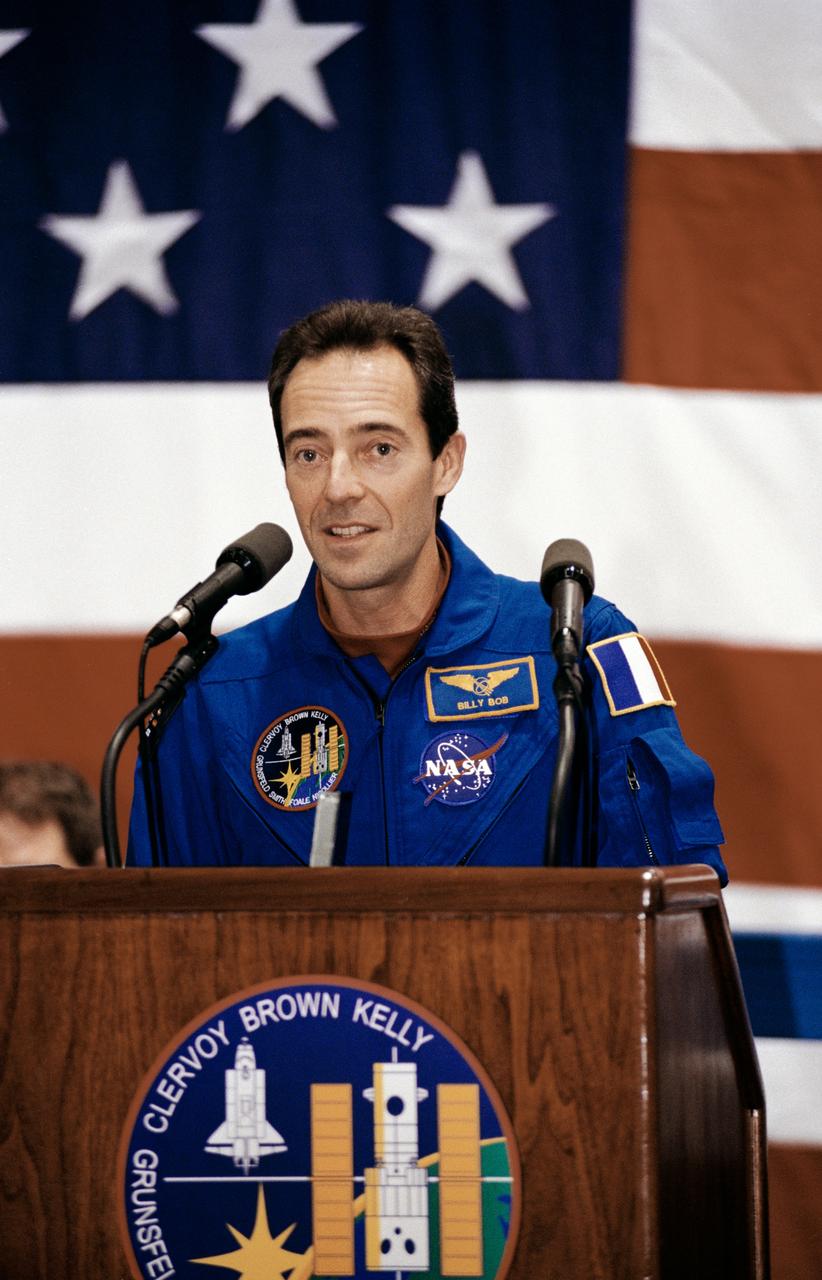 Photographic documentation showing STS-103 crew return at bldg. 990, Ellington Field. Views include: Mission Specialist (MS) John M. Grunsfeld at podium (16048); MS Jean-Francois Clervoy at podium (16049); Grunsfeld signs autographs (16050); woman and child (16051); MS Claude Nicollier meets his Swiss-American fan club (16052); Clervoy holds child (16053); mission commander Curtis L. Brown signs autographs (16054, 16057); MS E. Michael Foale signs autographs (16055); MS and Payload Commander (PLC) Steven L. Smith kneels and holds child (16056); overall view of stage showing Brown at podium with crew seated behind him; from left to right: Nicollier, pilot Scott J. Kelly, Clervoy, Grunsfeld, Mr. George Abbey (JSC director), Foale and Smith (16058); Nicollier at podium (16059); Mr. George Abbey at the podium (16060): Foale ath the podium (16061); Kelly signs autographs (16062).