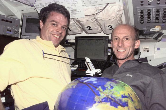 S99-E-5259  (13 February 2000) --- Astronauts Kevin R. Kregel (left), mission commander, and Gerhard P.J. Thiele demonstrate mapping techniques for the Space Radar Topography Mission (SRTM) using a payload-equipped model and a globe on Endeavour's flight deck. The two are joined by astronaut Janet L. Kavandi, mission specialist, on the SRTM's Red Team.  Thiele is a mission specialist representing the European Space Agency (ESA).