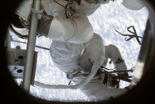 NASA image: View of crewmen performing EVA taken from inside OWS