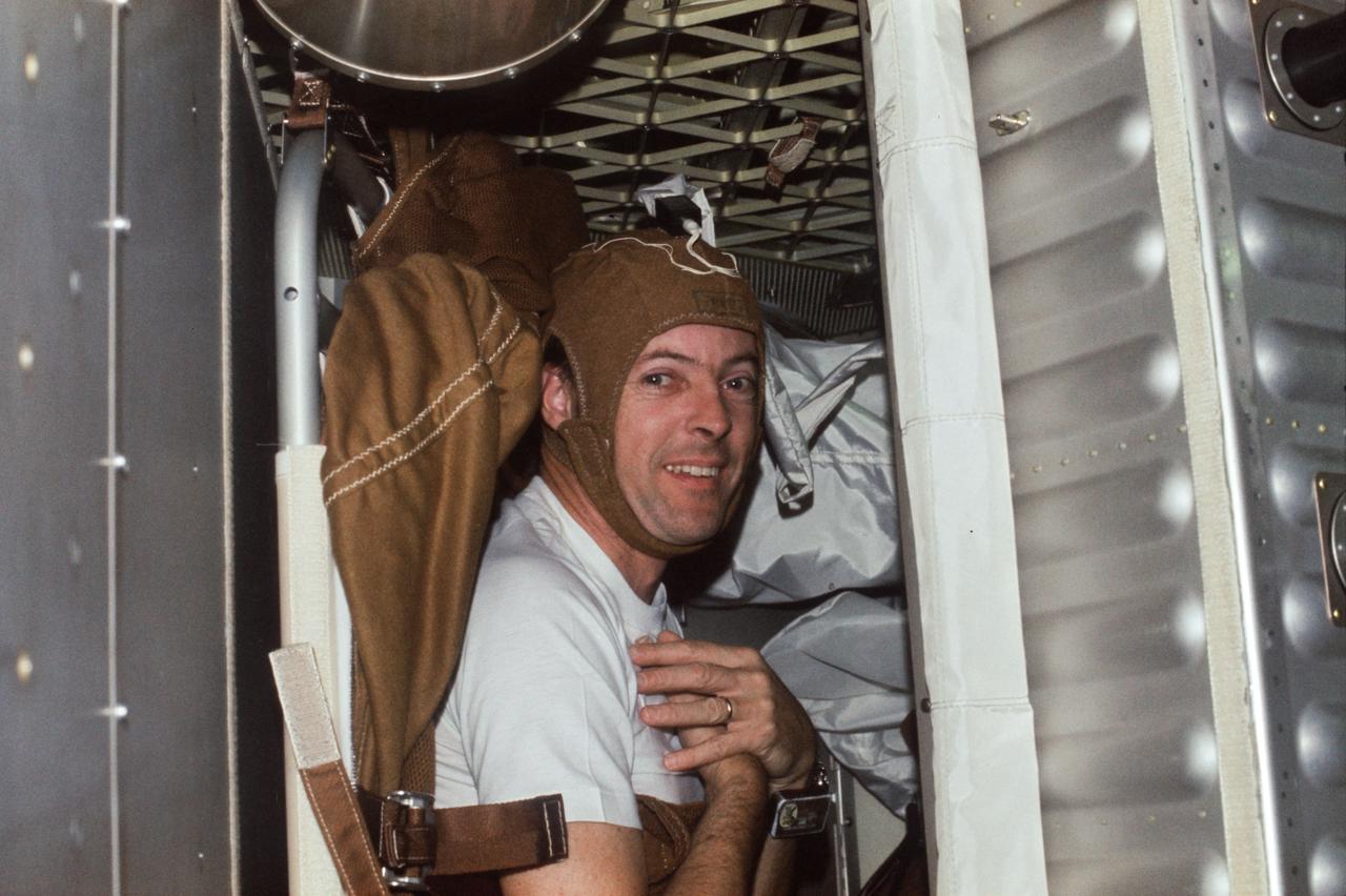 SL2-X3-205 (June 1973) --- Scientist-astronaut Joseph P. Kerwin, Skylab 2 science pilot, is photographed strapped into the sleep restraint in the crew quarters of the Orbital Workshop of the Skylab 1 & 2 space station cluster in Earth orbit. Kerwin is wearing the special cap which contains biomedical instrumentation for the M133 Sleep Monitoring Experiment. The purpose of the M133 experiment is to evaluate quantity and quality of sleep during prolonged space flight by the analysis of electroencephalographic (EEG) and electrooculographic (EOG) activity. Photo credit: NASA