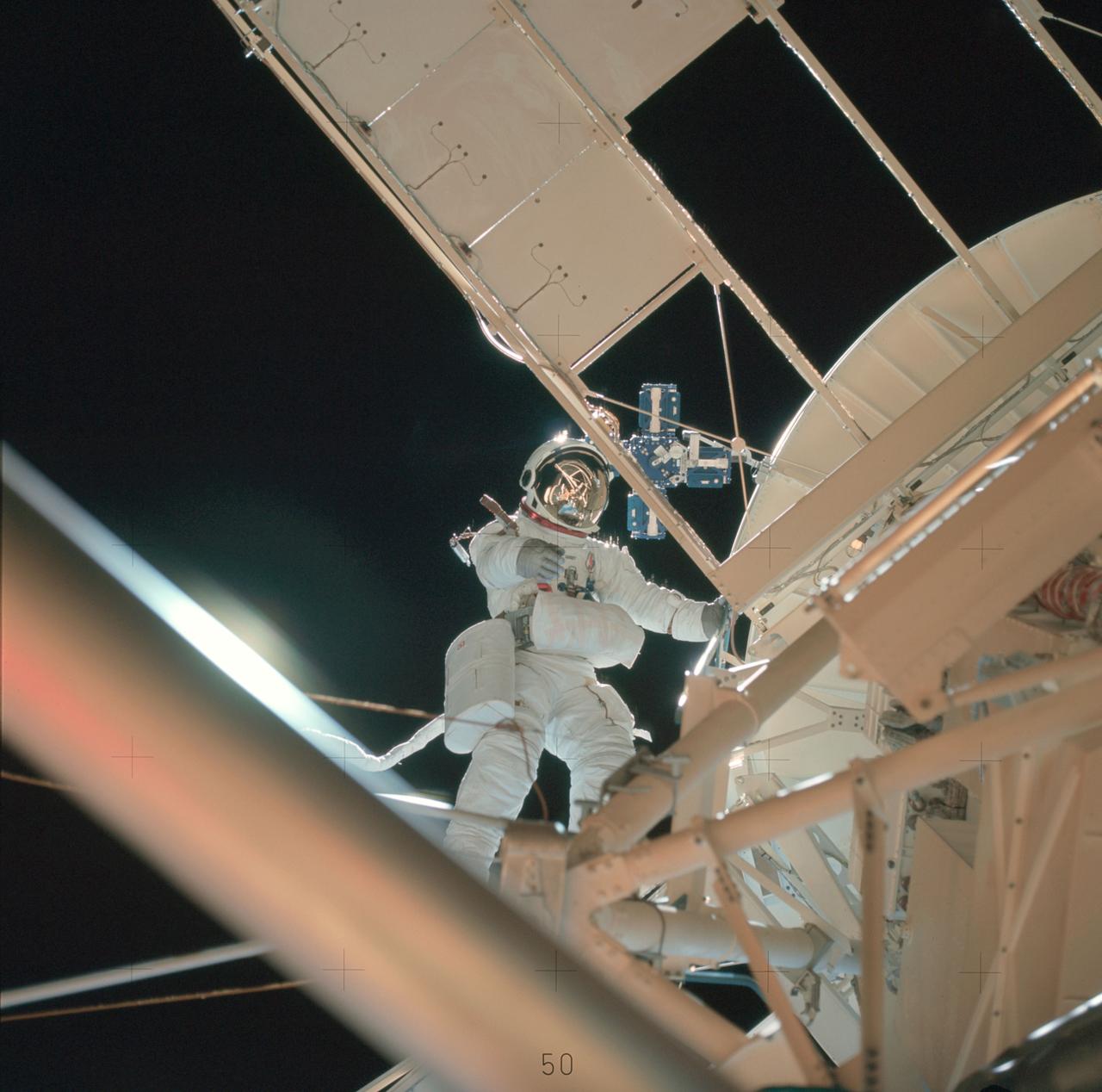 Scientist-Astronaut Owen K. Garriott, Skylab 3 science pilot, participates in the August 6, 1973 extravehicular activity (EVA) during which he and Astronaut Jack Lousma, Skylab pilot, deployed the twin pole solar shield to help shade the Orbital Workshop (OWS). Note the reflection of the solar shield in Garriett's helmet visor.