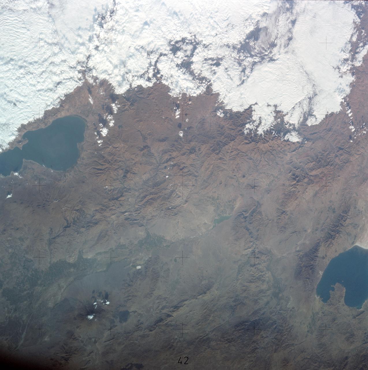 SL3-122-2562 (July-September 1973) --- A near vertical view of the border area of Turkey-Iran?Union of Soviet Socialist Republics as seen from the Skylab space station in Earth orbit. This picture was taken by one of the Skylab 3 crewmen using a hand-held 70mm Hasselblad camera. THE PICTURE SHOULD BE HELD WITH THE MASS OF WHITE CLOUDS ON THE RIGHT SIDE. The lake at the top center edge is Ozero (Lake) Sevan in the USSR?s Armenian Soviet Socialist Republic. The other body of water is Iran?s Lake Urmia. The major feature in this photograph can be seen in the upper left corner. Mount Ararat is in Turkey only a few miles from Iran and USSR borders. Yerevan, the capital of Armenian SSR, is located north-northwest of Mount Ararat. Photo credit: NASA