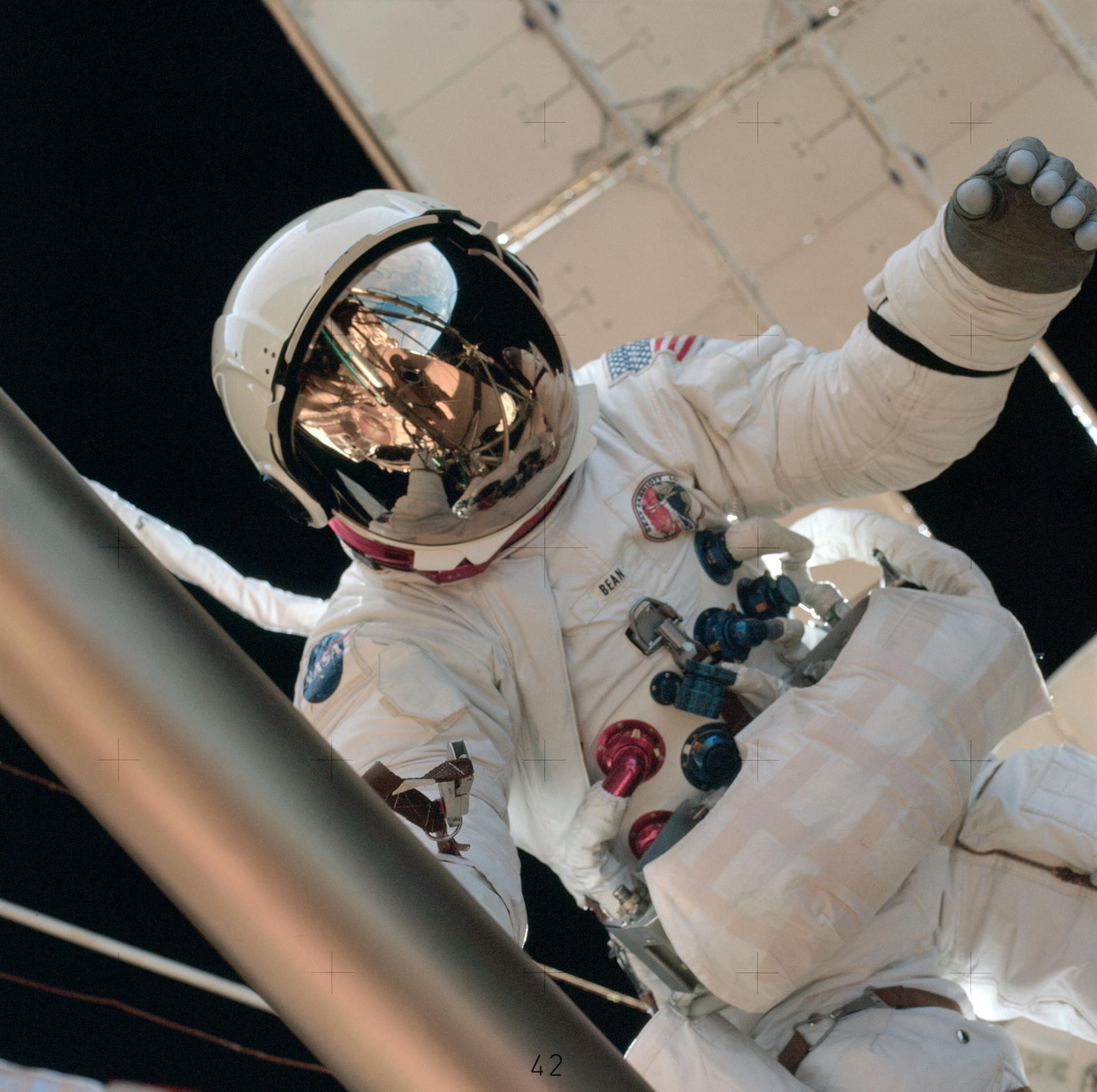 Astronaut Al Bean wears a white space suit as he performs a spacewalk on the exterior of the Skylab space station in 1973