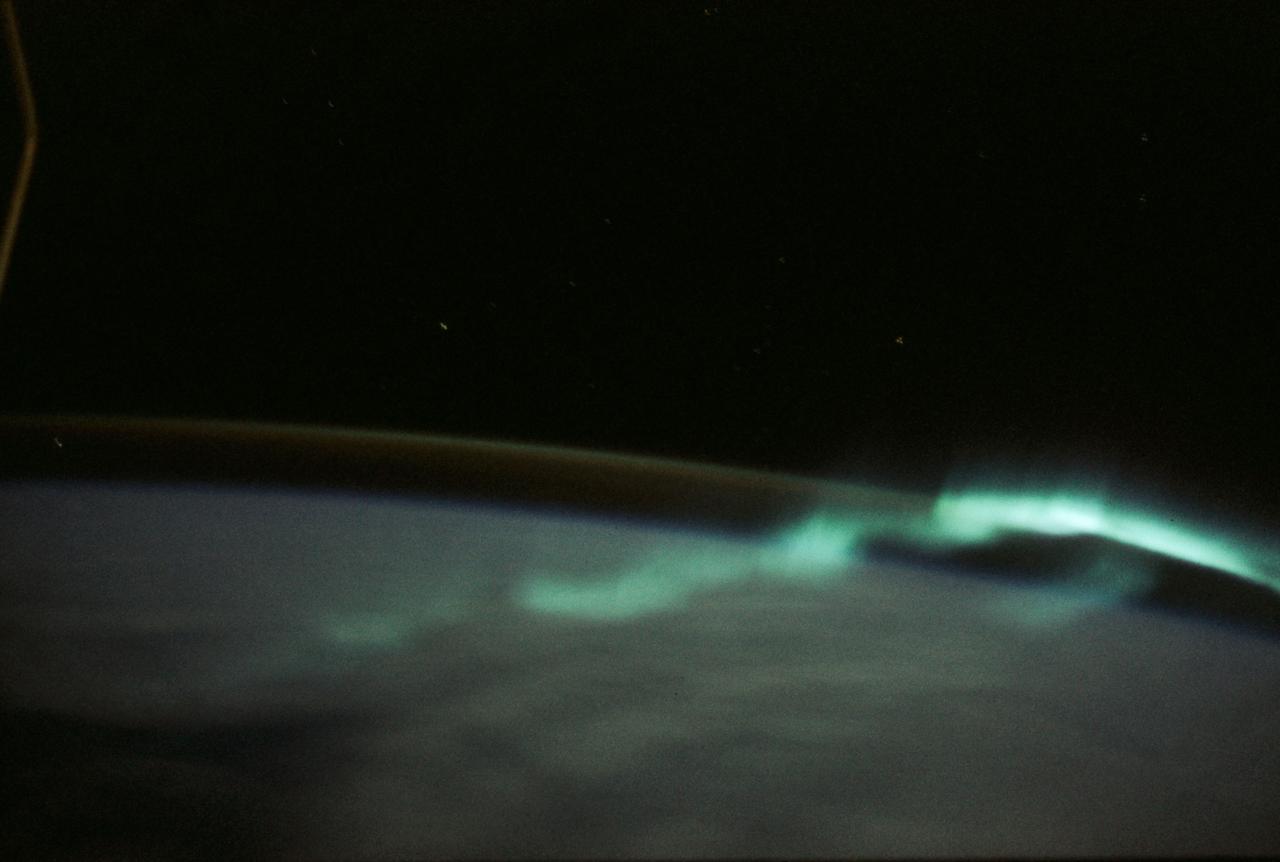 SL3-130-3130 (July-September 1973) --- An excellent view of the southern aurora, luminous bands or streamer of light, in the Southern Hemisphere, as photographed from the Skylab space station in Earth orbit. The space station was moving into the sunlight when this picture was taken. This view is near the edge of the aurora cap. The surface of the Earth is in the foreground. The permanent aurora over the South Pole is in the background. Scientist-astronaut Owen K. Garriott, Skylab 3 science pilot, took this photograph with a hand-held 35mm Nikon camera, with a four-second exposure at f/1.2, using high-speed Ektacrome film. Because auroras are caused by solar activity, they occur at the same time in the Northern and Southern hemispheres. Photo credit: NASA
