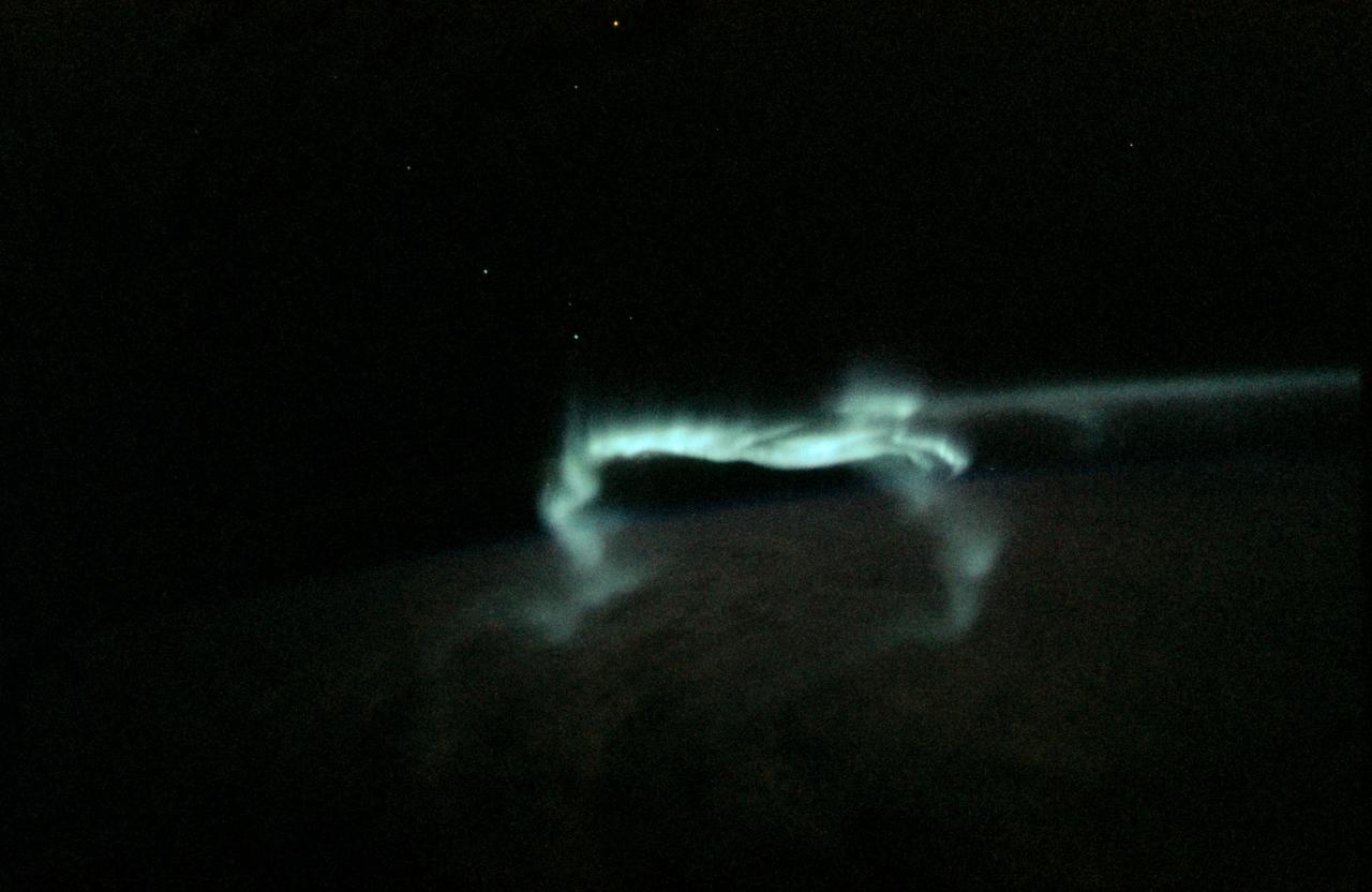 SL3-130-3131 (July-September 1973) --- An excellent view of the southern aurora, luminous bands or streamers of light, in the Southern Hemisphere, as photographed from the Skylab Space Station in Earth orbit. The space station was moving into the sunlight when this picture was taken. This view is near the edge of the aurora cap. The surface of Earth is in the foreground. The permanent aurora over the South Pole is in the background. Scientist-astronaut Owen K. Garriott, Skylab 3 science pilot, took this photograph with a hand-held 35mm Nikon camera, with a four-second exposure at f/1.2, using high-speed Ektachrome film.  Because auroras are caused by solar activity, they occur at the same time in the Northern and Southern hemispheres. Photo credit: NASA