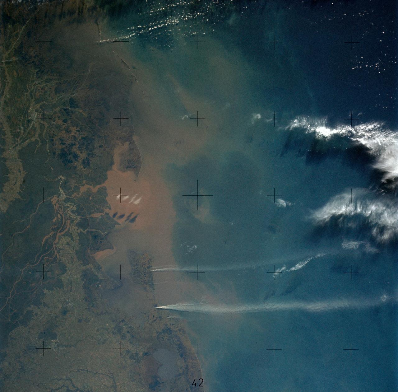 SL4-136-3475 (February 1974) --- A vertical view of the Gulf coast area of Louisiana (29.0N, 92.0W) as seen from the Skylab space station in Earth orbit. A Skylab 4 crewman used a hand-held 70mm Hasselblad camera to take this picture. This view extends from White Lake and Pecan Island (bottom border) eastward to the Mississippi River delta (top left). Atchafalaya Bay (red) is in the center. The Bayou Teche area is included in this view. A prominent feature of this photograph is two large white smoke plumes extending from Louisiana south into the Gulf of Mexico. The larger smoke plume originates on the southern shore of Vermillion Bay. The other plume extends from the southern shore of Marsh Island. The prononced narrow width and length of the plumes indicate that a strong offshore wind is present. Approximately 100 miles of the plumes are visible in this photograph; but they probably extend well into the Gulf of Mexico. Photo credit: NASA
