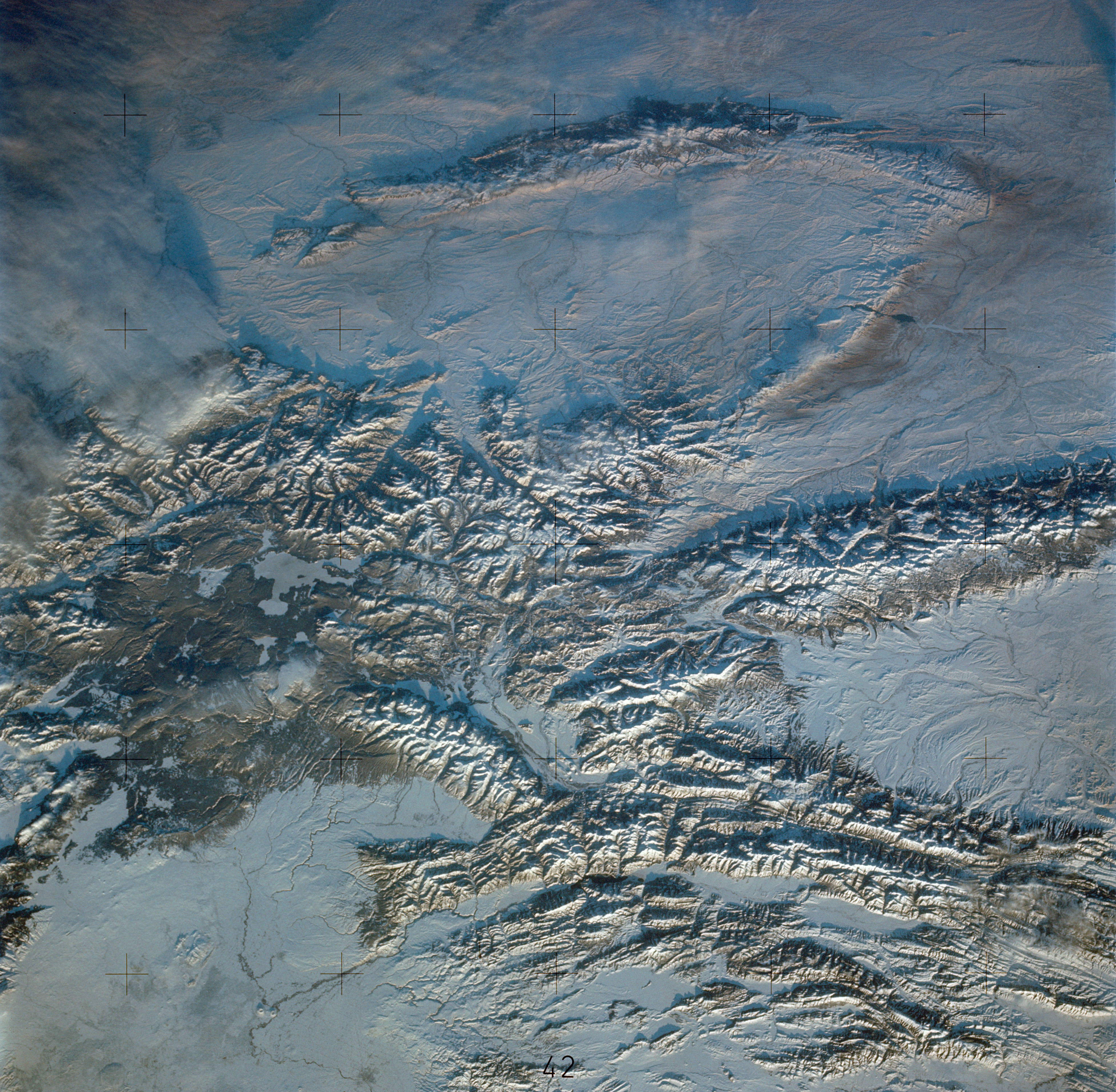 SL4-138-3846 (February 1974) --- A near vertical view of the snow-covered northwest corner of Wyoming as seen from the Skylab space station in Earth orbit. A Skylab 4 crewman used a hand-held 70mm Hasselblad camera to take this picture. A small portion of Montana and Idaho is seen in this photograph also. The dark area is Yellowstone National Park. The largest body of water is Yellowstone Lake. The Absaroka Range is immediately east and northeast of Yellowstone Lake. The elongated range in the eastern part of the picture is the Big Horn Mountain range. The Wind River Range is at bottom center. The Grand Teton National Park area is almost straight south of Yellowstone Lake. Approximately 30 per cent of the state of Wyoming can be seen in this photograph. Photo credit: NASA