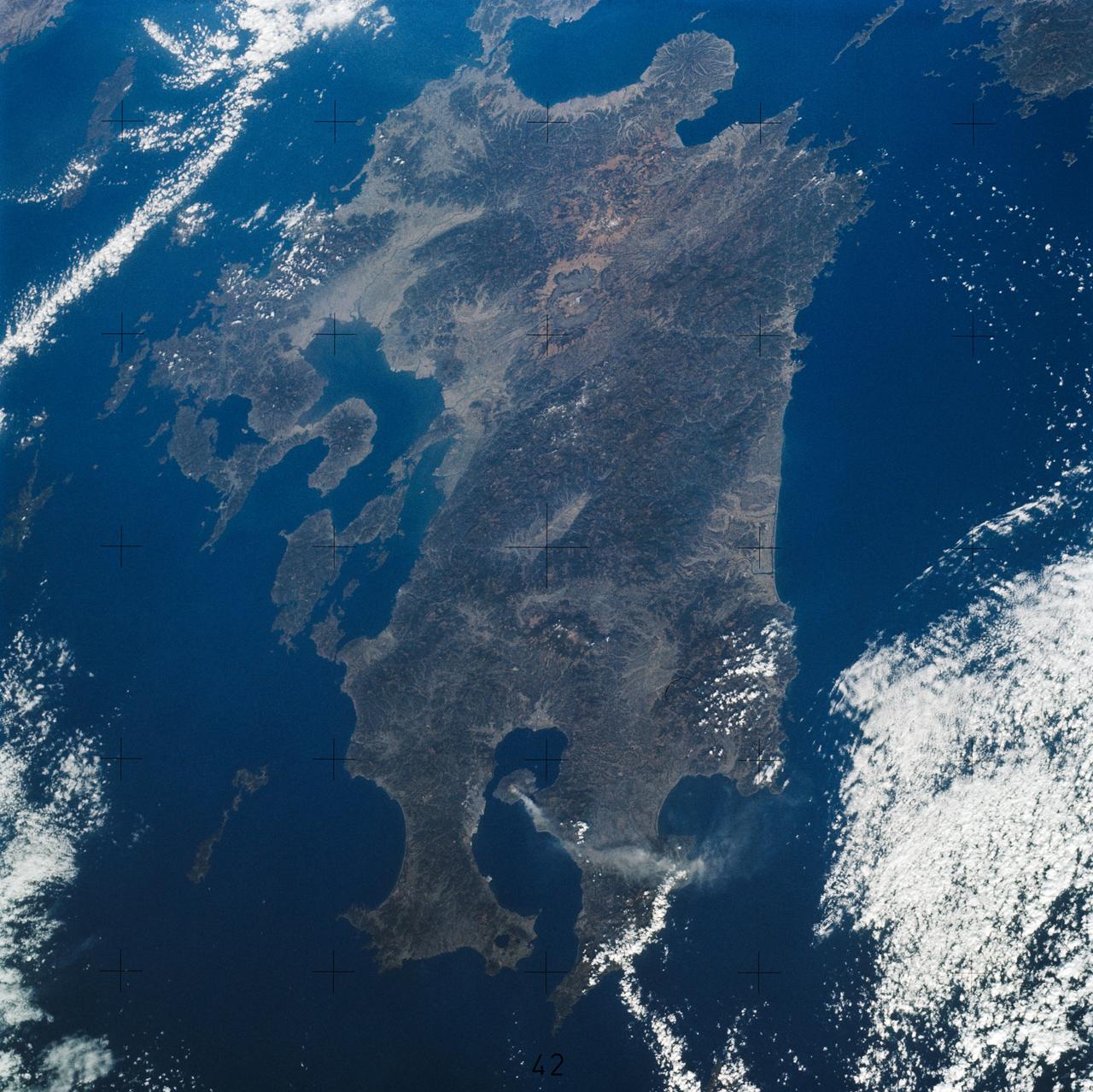 SL4-139-3942 (7 Jan. 1974) --- This oblique view of the Island of Kyushu, Japan, was taken from the Earth-orbiting Skylab space station on Jan. 8, 1974 during its third manning. A plume from the volcano Sakurajima (bottom center) is clearly seen as it extends about 80 kilometers (50 miles) east from the volcano. (EDITOR'S NOTE: On Jan. 10, 2013, a little over 39 years after this 1974 photo was made from the Skylab space station, Expedition 34 crew members aboard the International Space Station took a similar picture (frame no. ISS034-E-027139) featuring smoke rising from the same volcano, with much of the island of Kyushu visible. Interesting comparisons can be made between the two photos, at least as far as the devices used to record them. The Skylab image was made by one of the three Skylab 4 crew members with a hand-held camera using a 100-mm lens and 70-mm color film, whereas the station photo was taken with 180-mm lens on a digital still camera, hand-held by one of the six crew members). Photo credit: NASA