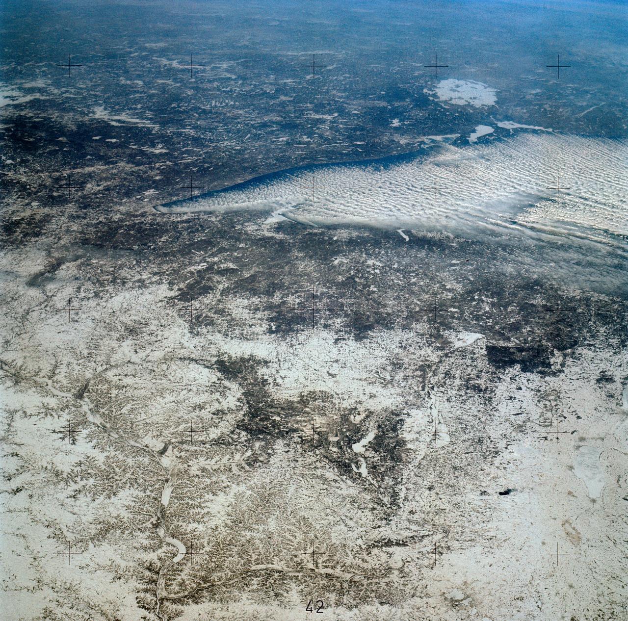SL4-139-3953 (7 Jan. 1974) --- An oblique view of a portion of the Middle West looking northeastward toward Lake Superior and Ontario, Canada, as seen from the Skylab space station in Earth orbit. This picture was taken by one of the Skylab 4 crewmen with a hand-held 70mm Hasselblad camera using a 100mm lens. Most of the land mass in the foreground is Wisconsin. Iowa is in the lower left corner. Minnesota is at left and upper left. Ontario is in the far right background. Michigan is at right center. Note the circular-shaped feature at center left which was first observed by the Skylab 4 crewmen. The feature is 85 kilometers (55 miles) in diameter, and it is centered near 91.5 degrees west longitude and 44.5 degrees north latitude. The Mississippi River Valley forms the southwest side of the circular feature. The City of La Crosse, Wisconsin, is just south of the near side of the circle, and the Black River completes the southern and eastern part. The City of Eau Claire is at the north edge of the circle. The most likely origin of circular features of this magnitude are (1) volcanic, (2) structural, or (3) meteorite impact. The feature is not volcanic -- the rocks are the wrong type. Possibly it is structural, formed by slight warping of layered rocks into a basin or dome, followed by erosion of all but the most subtle trace of the structure. The feature could be a severely eroded meteorite impact crater. If so, a thorough study of the area may yield evidence of the extreme pressure and temperature the rocks were subjected to by the shock of an impacting meteorite. Photo credit: NASA