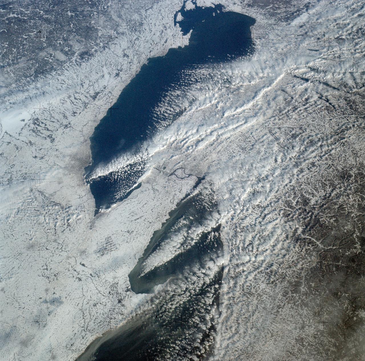 SL4-139-3989 (February 1974) --- An oblique view of a portion of the Great Lakes area as seen from the Skylab space station in Earth orbit. This picture was taken with a hand-held 70mm Hasselblad camera. Lake Erie is in the foreground; and Lake Ontario is in the background. The Niagara Falls area is in the center of the photograph. Portions of Pennsylvania, New York, and Ontario, Canada are visible, but under nearly complete snow cover. Major structural features, drainage patterns, road systems and the cities of Buffalo and Toronto are easily distinguished and actually enhanced by the snow. At the time this picture was taken, these two Great Lakes had no observable ice, although cloud formations partially mask the southern shores of the two bodies of water. James Barnes, a snow-pattern expert, will analyze Skylab photographs like this one to gain further knowledge of snow cover over land masses. Photo credit: NASA