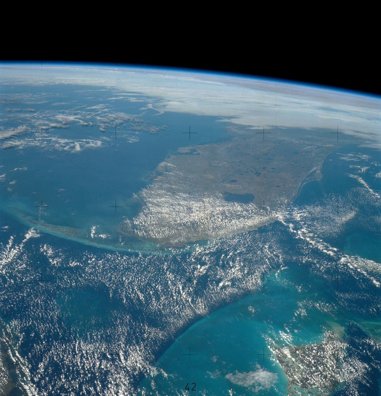 SL4-139-4029 (10 Jan. 1974) --- An oblique view of the State of Florida, looking northward up the peninsula, as photographed from the Skylab space station in Earth orbit by one of the Skylab 4 crewman. The camera used was a hand-held 70mm Hasselblad, with SO-368 medium-speed Ektachrome. This view shows almost the entire state, except the panhandle region. The Bahama Banks area appears in the southeast part of the picture as the light blue water. Andros Island in the Bahamas group is the island in the lower right corner. The Gulfstream flows between Florida and the Bahama Banks. This fast-moving, warm-water current transports energy from the tropics to the northern latitudes. The effect of the warmer Gulfstream waters on the atmosphere is seen as increased convection (caused by the warmer water heating the air from below) resulting in the fair weather cumulus seen confined primarily over the Gulfstream. A portion of Cuba is seen in the lower left corner of the picture. Photo credit: NASA