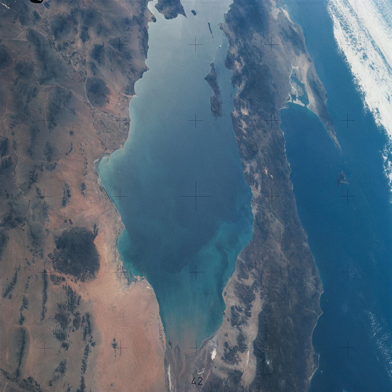 SL4-142-4548 (27 Jan. 1974) --- An oblique view of northwestern Mexico, as photographed from the Skylab space station in Earth orbit by one of the Skylab 4 crewmen. The camera used was a hand-held 70mm Hasselblad, with SO-368 medium-speed Ektachrome film. This photograph was taken on a sweep down the coast to document the fault patterns of southern California and northwest Mexico. SL4-142-4532 gives an excellent overview of the entire region. The specific reason for this picture was an attempt to see if the Agua Blanca Fault in Baja California extends to the east toward the Gulf of California. Several attempts were made by the Skylab 4 crew to visually detect such an extension, but none was found. The report was that the fault disappeared into an area of sand and heavily eroded material that obscured any feature that might be present deeper. This area of sand and loose material is the light-colored area in the center of Baja at the extreme north part of the photograph. In addition to this geology the Pinacate volcanic field in Sonora, the sand dunes in Sonora, and the sediment flow patterns of the Colorado River entering the Gulf are additional areas of study utilizing this photograph. Photo credit: NASA
