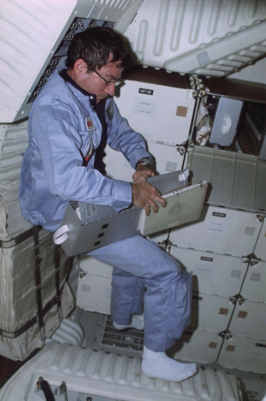 STS001-06-497 (12-14 April 1981) --- Astronaut John W. Young, STS-1 commander, opens one of the lockers in the space shuttle Columbia's middeck area. This photo was taken by astronaut Robert L. Crippen, pilot, using a 35mm camera. Photo credit: NASA
