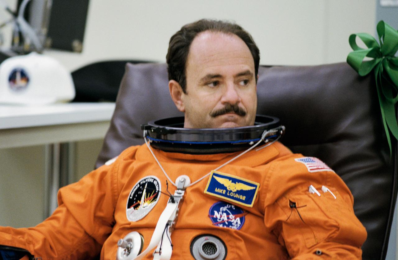 STS-26 Discovery, Orbiter Vehicle (OV) 103, Mission Specialist (MS) John M. Lounge relaxes in reclining chair after donning his orange launch and entry suit (LES) at the Kennedy Space Center (KSC) Operations and Checkout (O&C) Building. Upon completion of preflight suit tests, crewmembers will head to the launch pad.