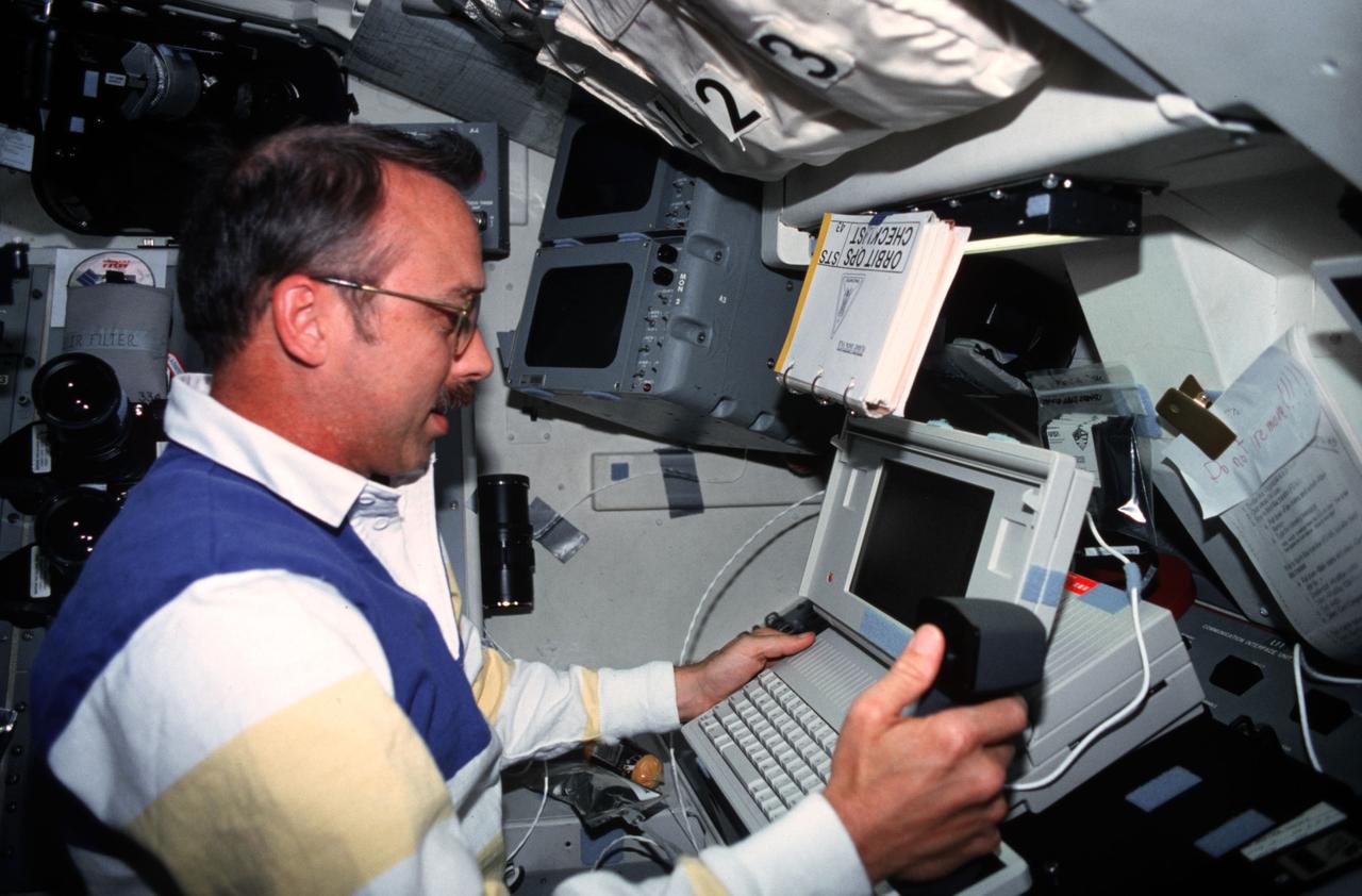 STS043-14-034   (2-11 Aug 1991) --- Astronaut James C. Adamson is pictured executing Development Test Objective (DTO) 1208, Space Station Cursor Control Device Evaluation II and Advanced Applications.  The purpose of the Cursor Control Device Experiment is to evaluate human performance under space flight conditions of cursor control devices which are similar to the devices under consideration for use onboard space station computers.  Here, the mission specialists uses a thumbball/handgrip control device.  Each crewmember evaluated the different types of cursor control devices during the nine-day STS-43 mission.  Other methods of cursor control evaluated were the built-in trackball, a side mounted trackball with restraints and an optical pad with mouse.