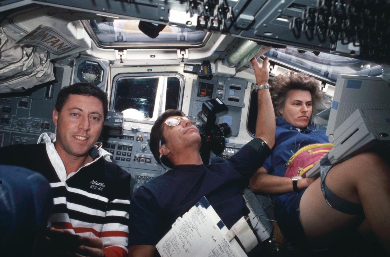 STS043-37-012 (2-11 Aug 1991) --- Three STS-43 astronauts are busy at work onboard the earth-orbiting space shuttle Atlantis.  Astronaut Shannon W. Lucid is pictured performing one of several tests on Computer hardware with space station applications in mind.  Sharing the aft flight deck with Lucid are Michael A. Baker (left), pilot and John E. Blaha, mission commander.