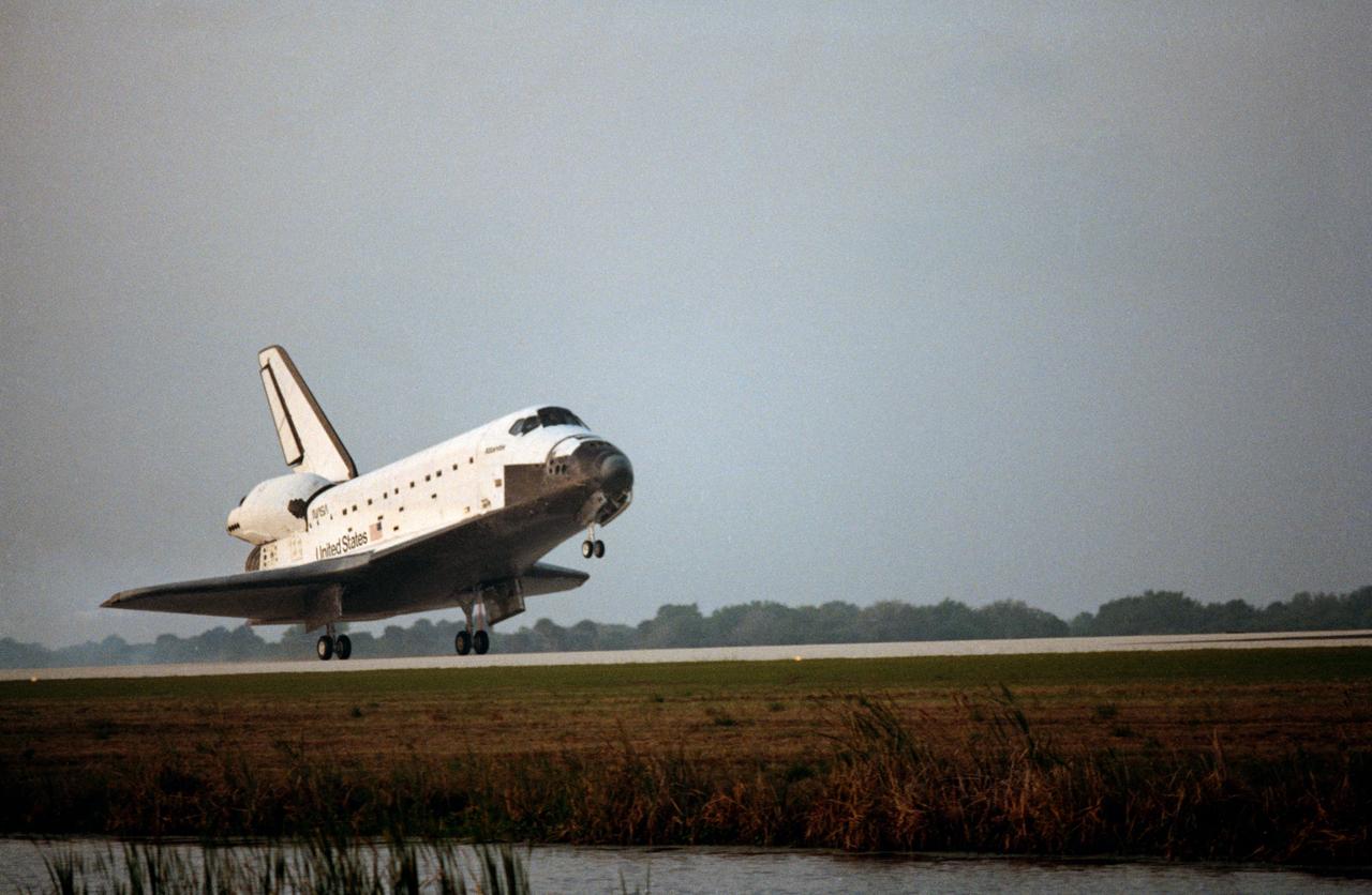 STS-45 Atlantis, Orbiter Vehicle (OV) 104, lands on concrete runway 33 at the Kennedy Space Center's (KSC's) Shuttle Landing Facility (SLF). The main landing gear (MLG) touched down at 6:23:06 am (Eastern Standard Time (EST)) in the early morning Florida fog as seen in these views. The deployed nose landing gear (NLG) rides above the runway before wheel stop.