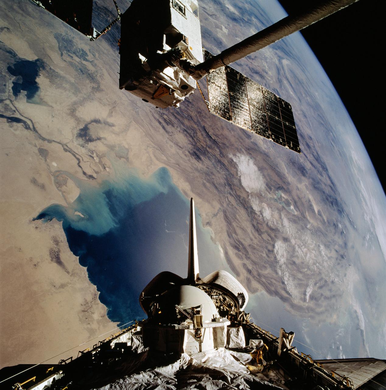 STS046-102-021 (1 Aug 1992) --- The European Space Agency's (ESA) EURECA satellite remains in the grasp of the Space Shuttle Atlantis' Remote Manipulator System (RMS) as the Space Shuttle passes over the Persian Gulf.  Most of the theater of the recent war is visible in the frame.  Parts of Kuwait, Iraq, Iran and Saudi Arabia can be delineated.  The Tethered Satellite System (TSS) remains stowed in the aft cargo bay of Atlantis.