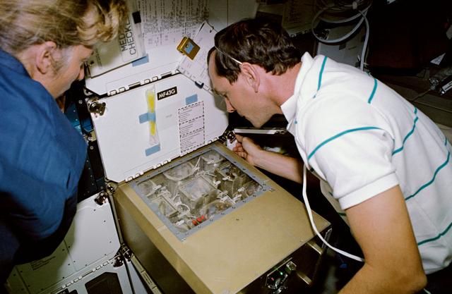 NASA image: STS-47 MS Davis and Pilot Brown monitor ISAIAH on OV-105's middeck