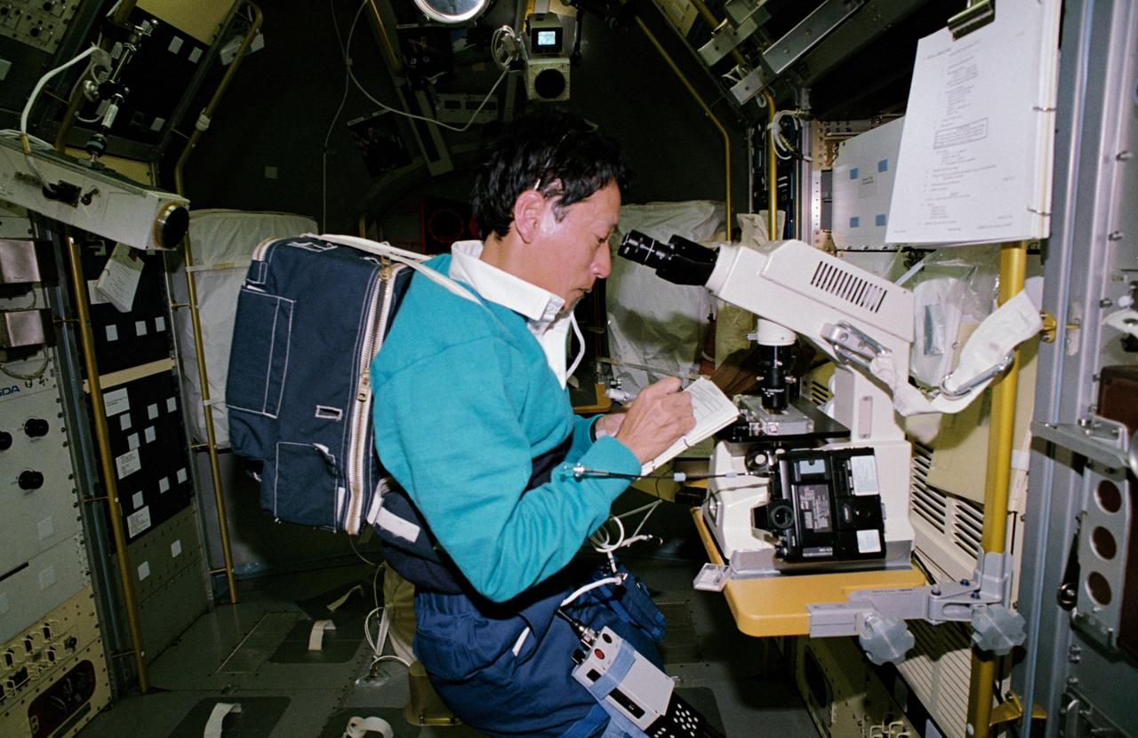 STS047-05-025 (12 - 20 Sept 1992) --- Payload specialist Mamoru Mohri, representing Japan's National Space Development Agency (NASDA), uses a microscope to produce photomicrographs of mammalian cells.  The mammal cell structure experiment is one of a large number of tests that were performed during the eight-day Spacelab-J mission.  On his back, Dr. Mohri totes a health monitoring experiment.  The primary objective of the physiological monitoring system is to observe the health condition of the Japanese payload specialist so that good health can be maintained during and after the spaceflight.