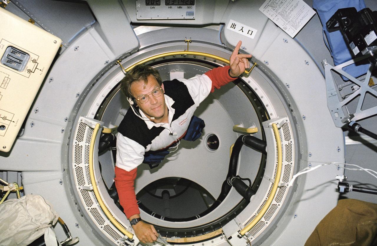 STS047-07-032 (12-20 Sept 1992) --- Astronaut Mark C. Lee, payload commander, floats through the tunnel that connects Spacelab-J's Science Module to the Space Shuttle Endeavour's cabin.  Lee was in the midst of a televised "tour" of the shuttle and its primary payload when he pointed to the Japanese sign overhead, which translates to, "EXIT-ENTRANCE".  Lee was joined by five NASA astronauts and a Japanese payload specialist for eight-days of research in support of the Spacelab-J project.